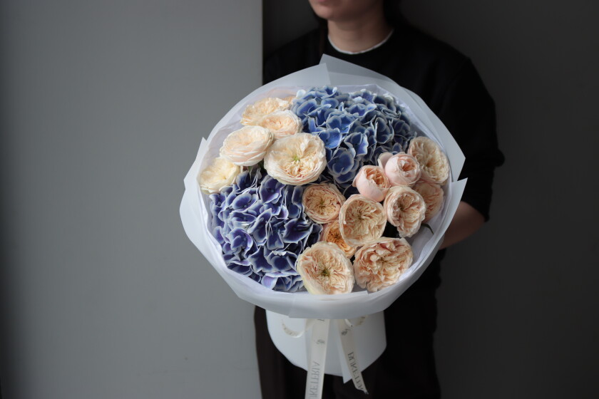 Peach spray roses with light blue hydrangeas