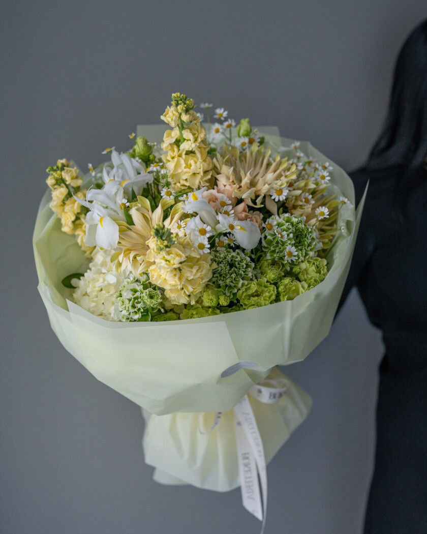 Six cream ranunculus with white gerberas and peach spray roses