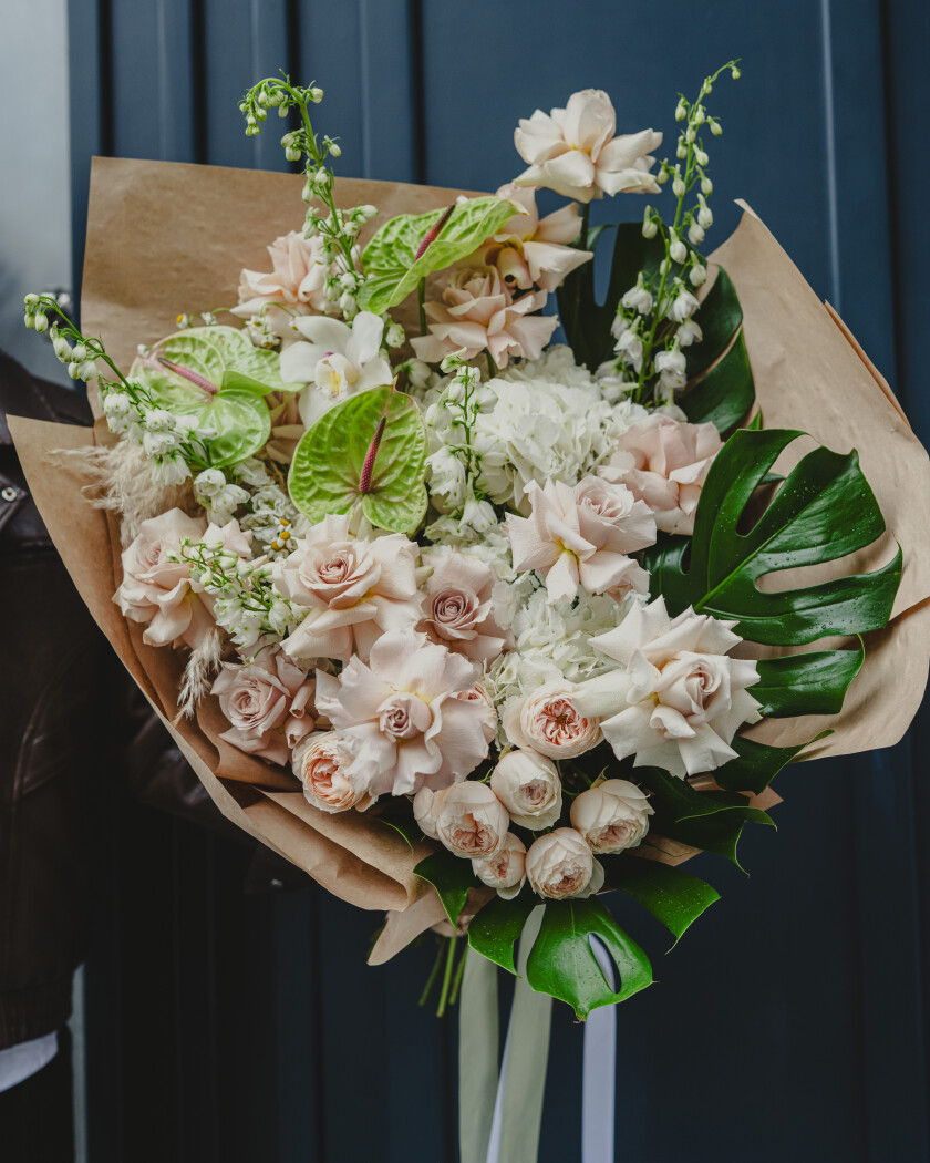 Blush garden roses with light blue delphiniums and green anthuriums