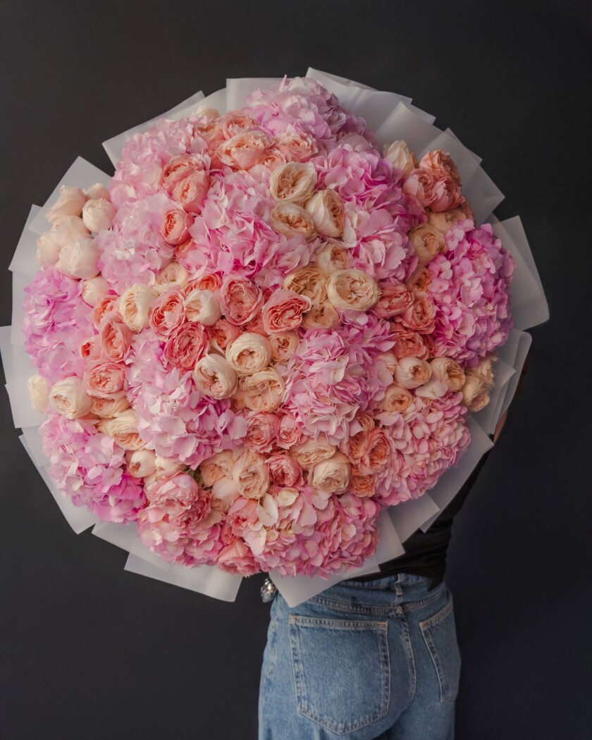 Mixed bouquet of pink hydrangeas, blush spray roses, and peach garden roses