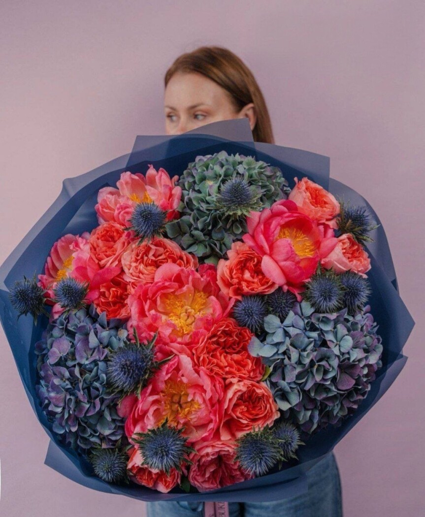 Coral peonies with blue hydrangeas and red garden roses