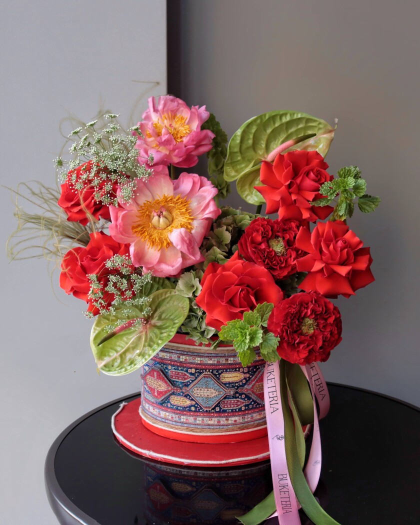 Five red hybrid tea roses with red anthuriums and pink peonies