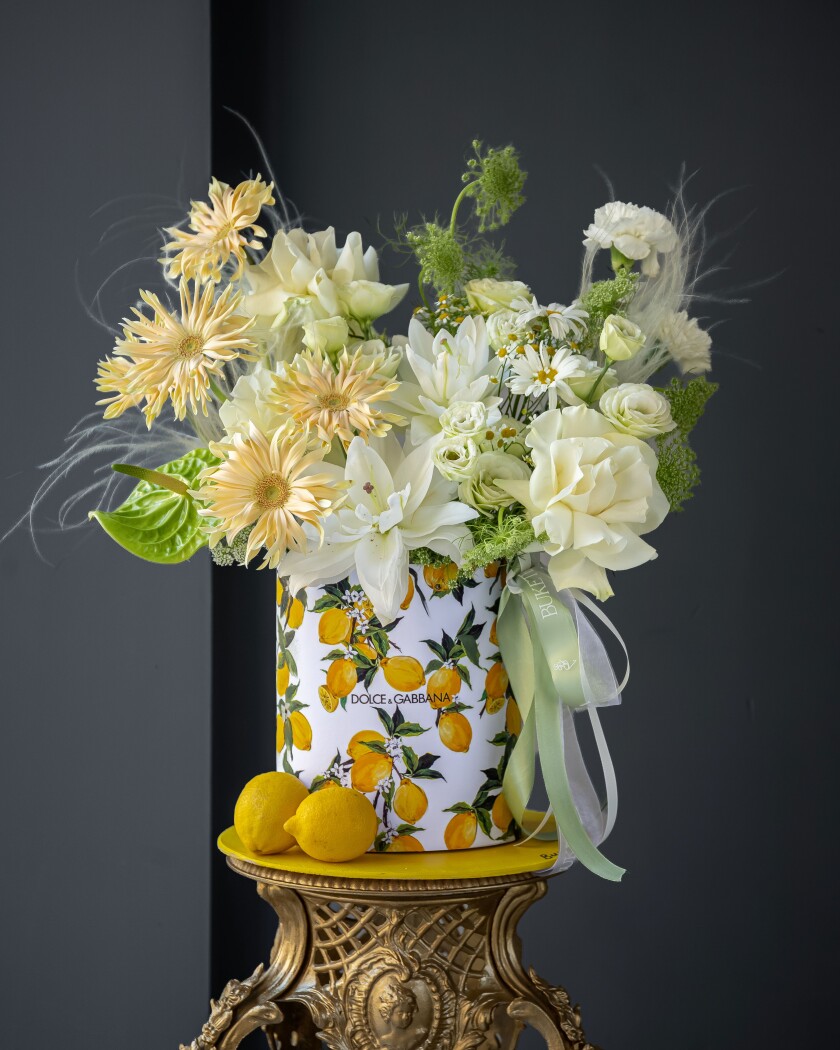 Decorative composition of light yellow gerberas and white roses in an art box