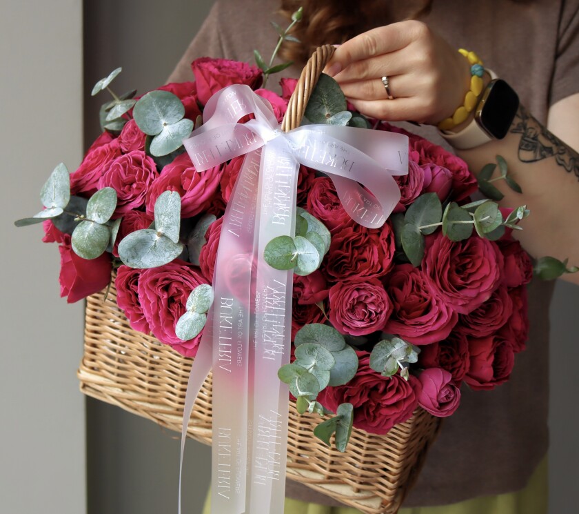 Fifteen deep pink spray roses in a rustic basket