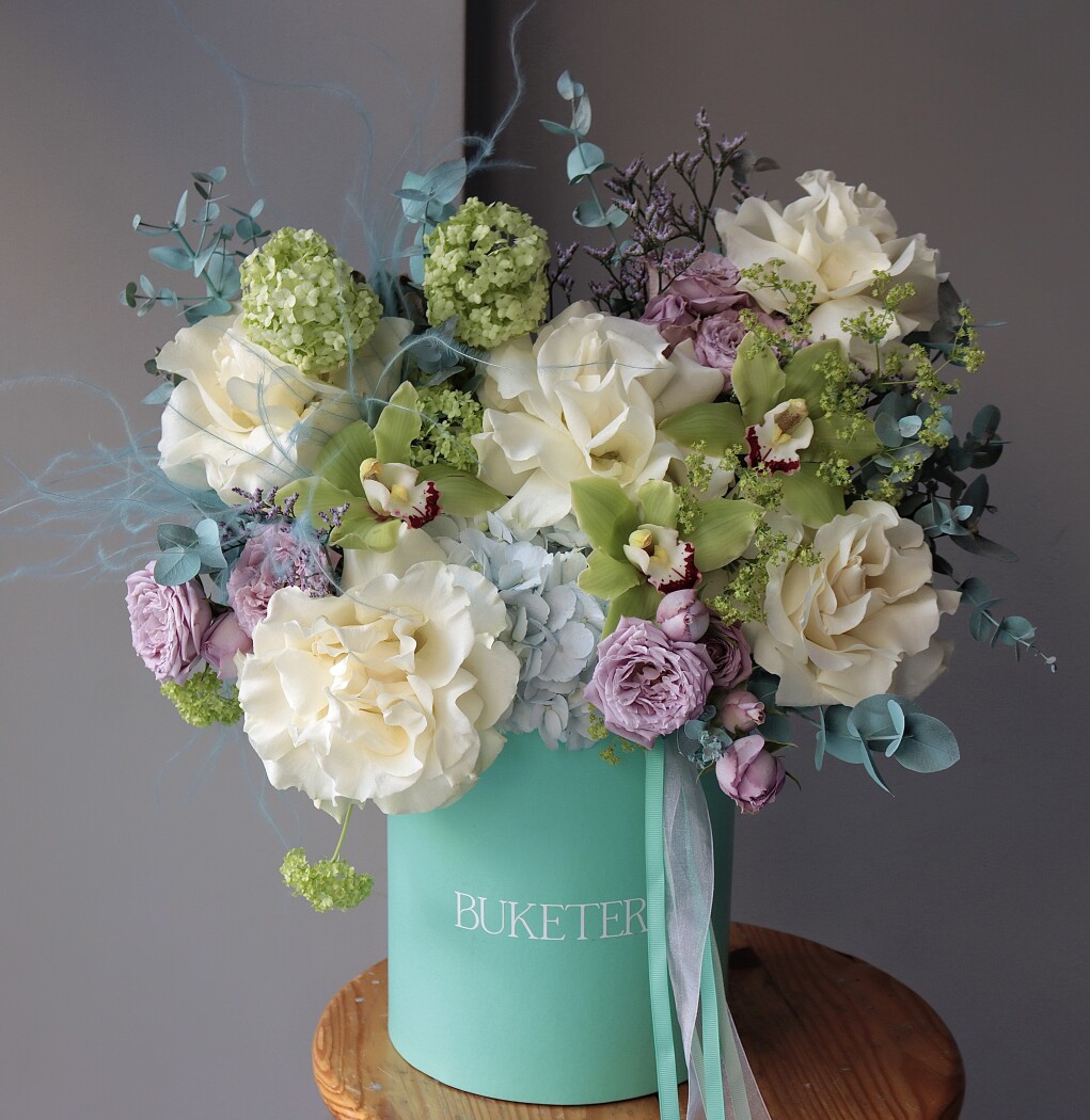 Decorative composition of cream garden roses and dusty pink spray roses