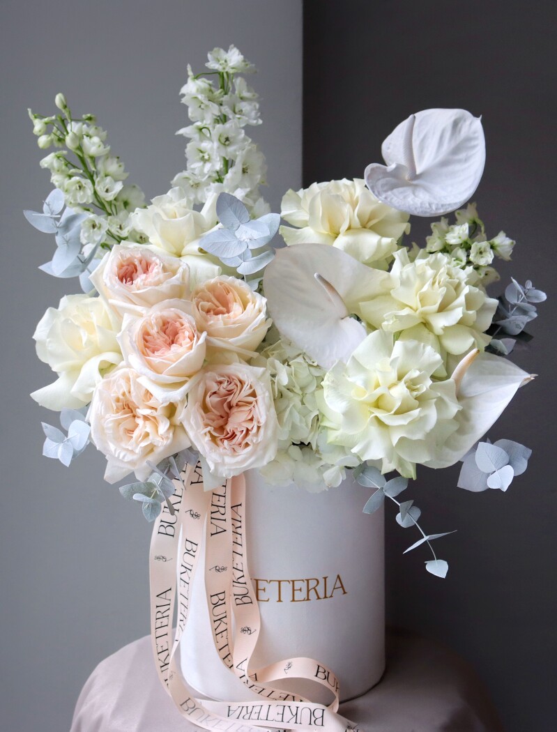 Peach and blush garden roses with white anthuriums and delphiniums