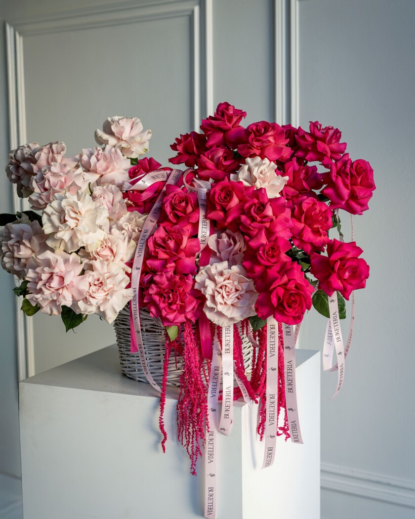 Asymmetric composition of pink garden roses and burgundy amaranth