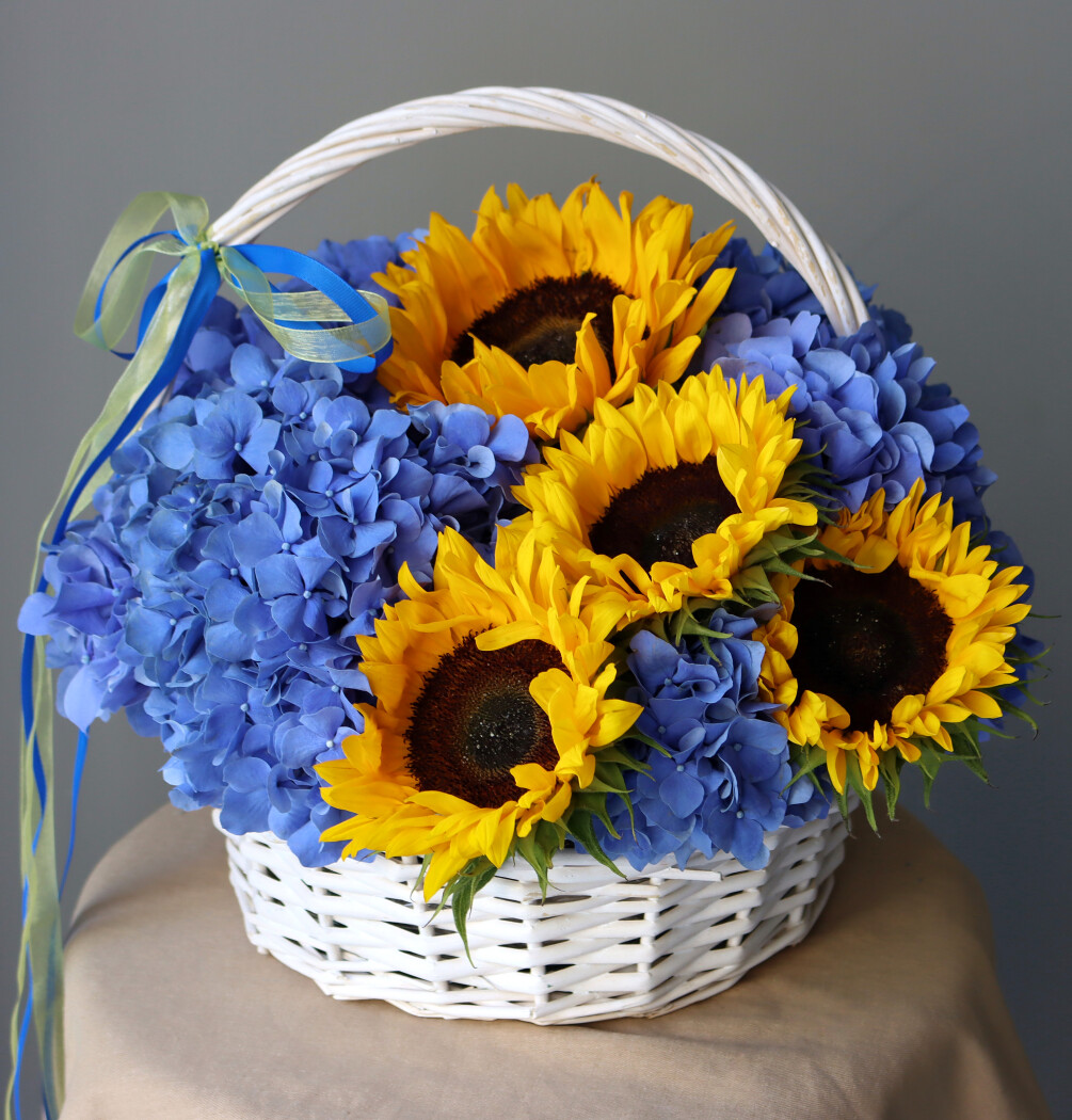 Decorative arrangement of blue hydrangeas and yellow sunflowers