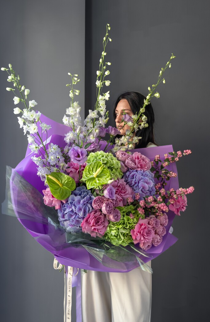Mixed bouquet of green and lilac hydrangeas, lavender delphiniums, and blush roses